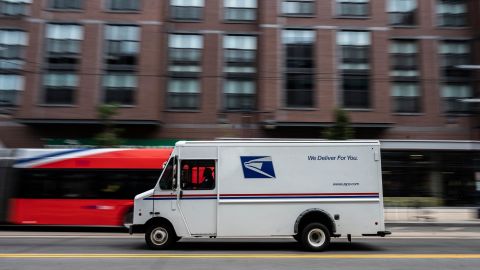 A postman drives a United States Postal Service mail delivery truck through Washington, DC, on August 13, 2021.