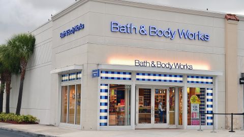  An employee with a face mask and shield cleans the door of Bath & Body Works store on July 21, 2020 in Pembroke Pines, Florida.