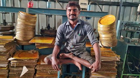 Kavala Krishnaiah, whose legs are not fully formed due to polio, makes disposable plates and bowls at Bollant Industries' manufacturing unit.