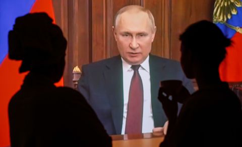 People in Moscow watch a televised address by Russian President Vladimir Putin as he announces a military operation in the Donbas region of eastern Ukraine on February 24. 