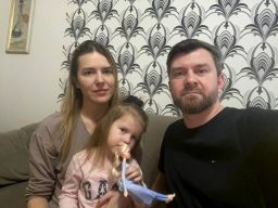 Yana and Sergii Lysenko sit with their 3-year-old daughter.