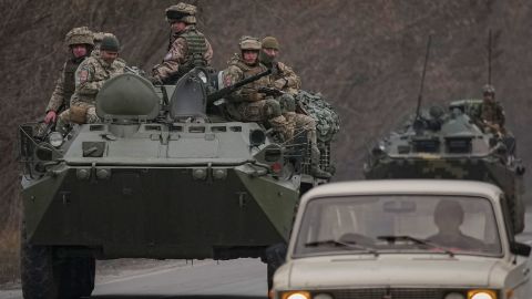 Ukrainian servicemen sit atop armored personnel carriers on a road in the Donetsk region, eastern Ukraine on Thursday.