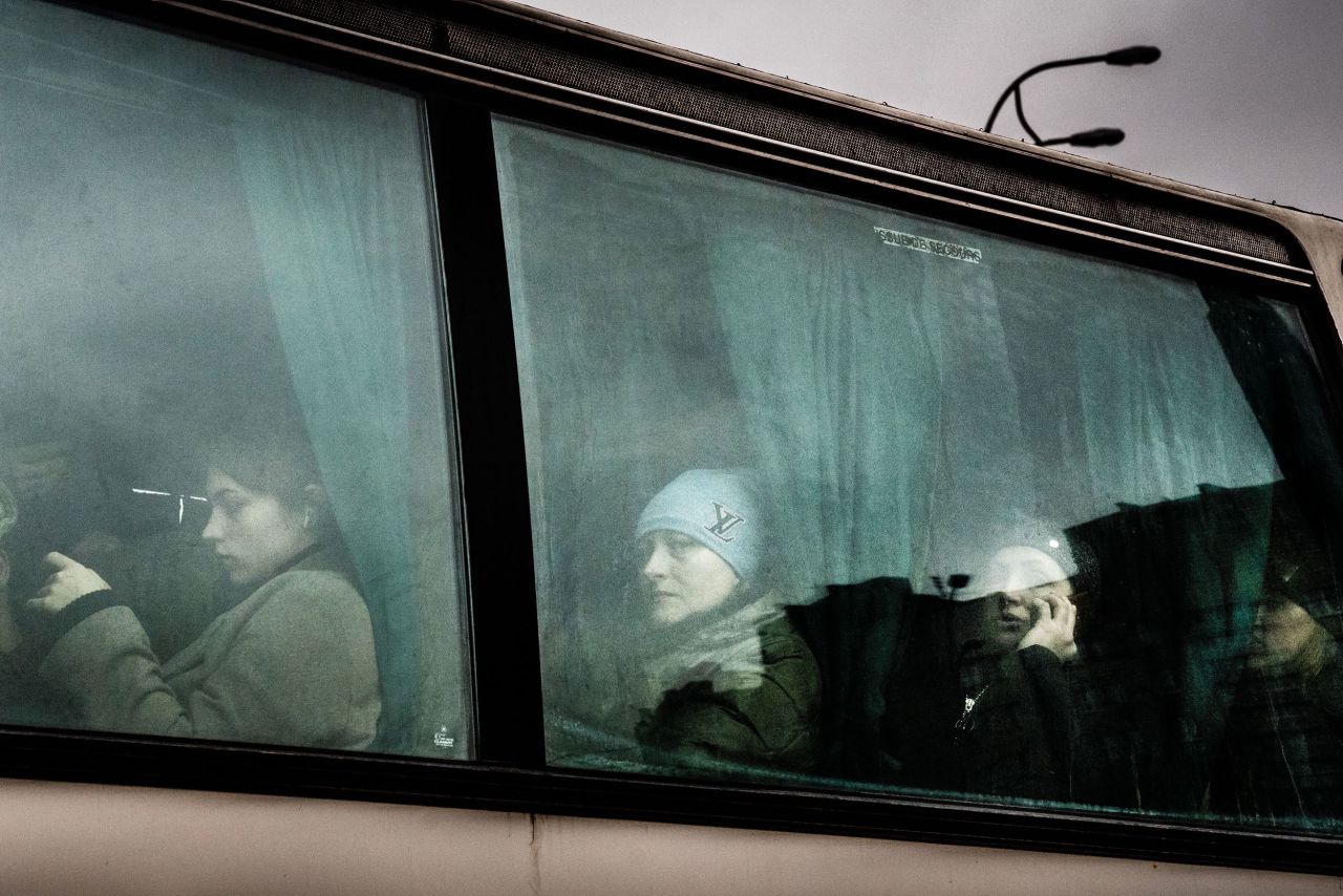 People wait after boarding a bus to leave Kyiv on February 24.