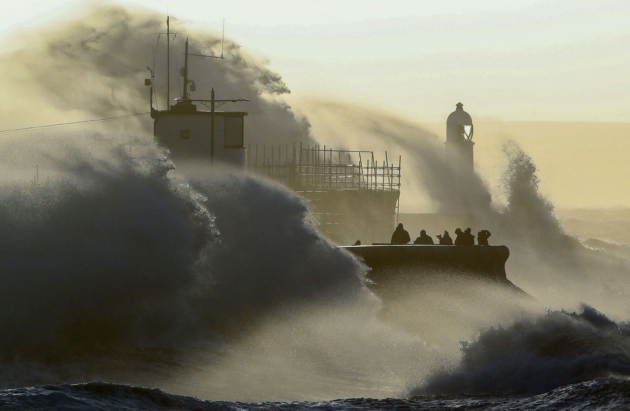 People watch as waves crash against the sea wall in Porthcawl, Wales, on Friday, February 18. <a href="https://www.cnn.com/2022/02/18/world/storm-eunice-landfall-weather-climate-intl-gbr/index.html" target="_blank">Storm Eunice</a> brought high winds across the region.