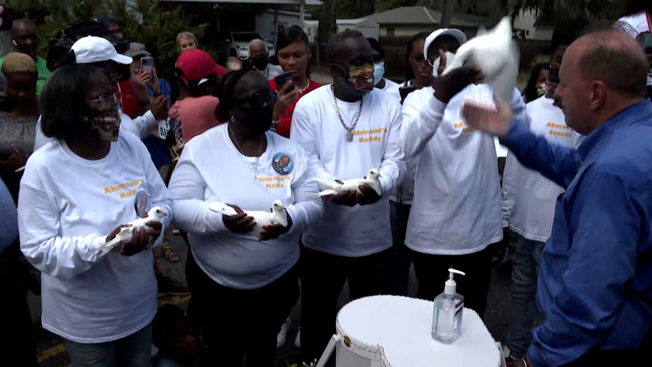 Arbery's father, Marcus Arbery Sr., (center) prepares to release a white dove in his son's honor
