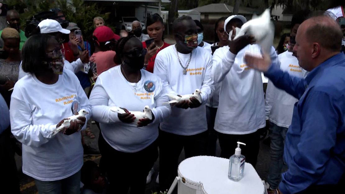 Arbery's father, Marcus Arbery Sr., (center) prepares to release a white dove in his son's honor