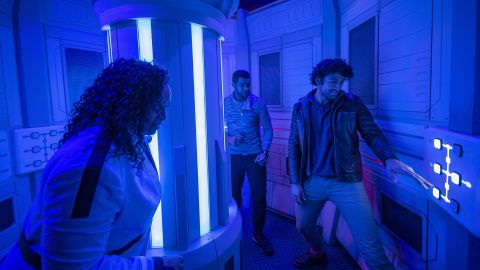 Cruise Director Lenka Mok (left) meets with passengers in the Halcyon starcruiser Engineering Room to discuss a secret mission.