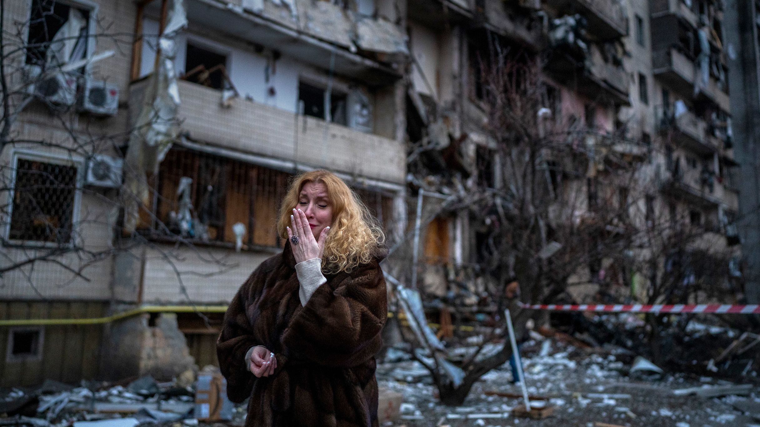 Natali Sevriukova reacts next to her house following a rocket attack on Kyiv on Friday, February 25, 2022.