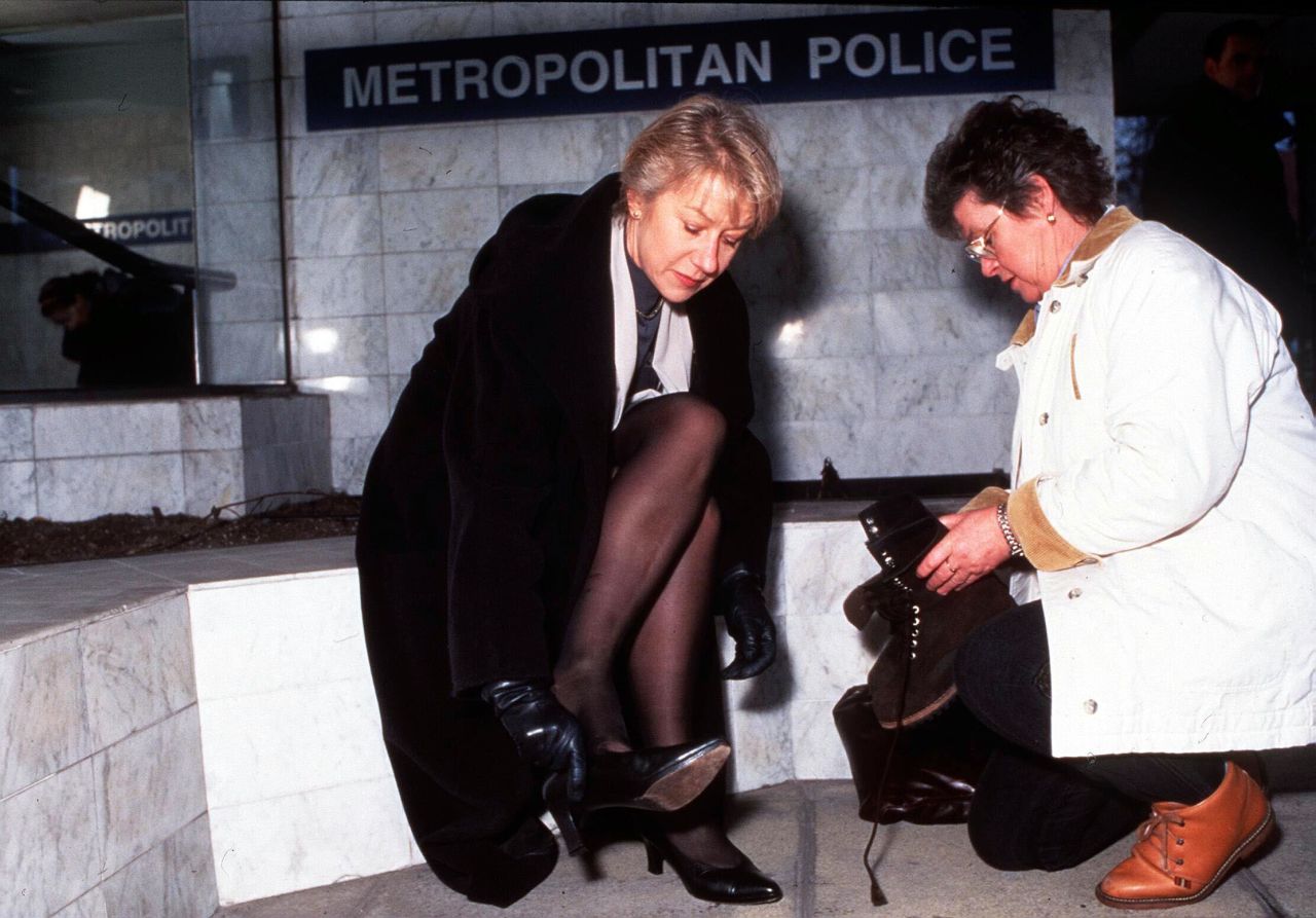 Mirren puts on a pair of shoes on the set of the series "Prime Suspect 4" in 1995.