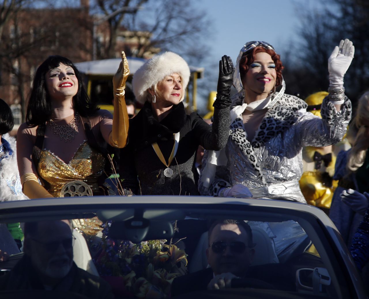 Mirren waves as she is paraded through Harvard Square alongside drag actors Tony Oblen, left, and Ethan Hardy. Helen was presented woman of the year by Harvard University's Hasty Pudding Theatricals in 2014.