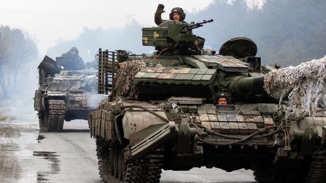 Ukrainian servicemen ride on tanks towards the front line with Russian forces in the Lugansk region of Ukraine on February 25, 2022. 