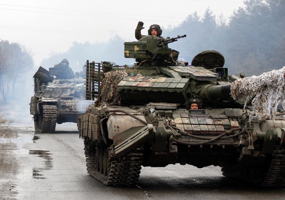 Ukrainian servicemen ride on tanks towards the front line with Russian forces in the Lugansk region of Ukraine on February 25, 2022. 