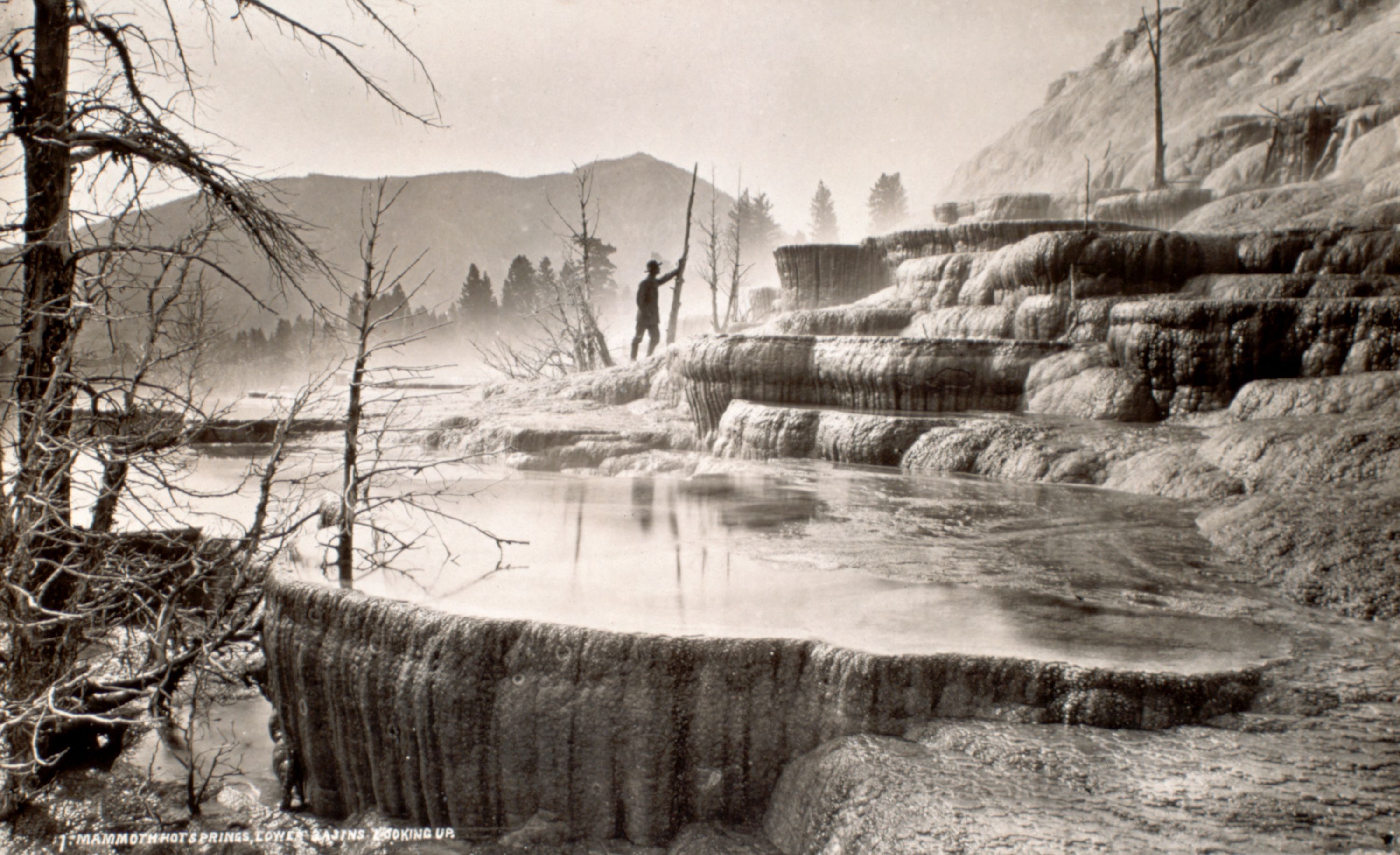 <strong>Mammoth Hot Springs:</strong> A man stands at the base of Mammoth Hot Springs circa 1869, before Yellowstone become the first national park in the United States.