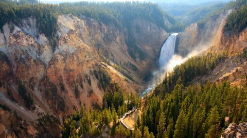 Sunlight illuminates the spray as the Yellowstone River crashes over the Lower Falls.