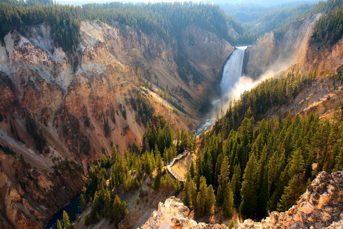 Sunlight illuminates the spray as the Yellowstone River crashes over the Lower Falls.