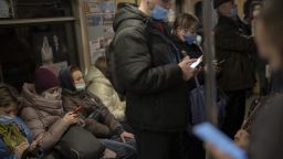 Commuters look at their phones as they travel in a local train in Kyiv, Ukraine, on Wednesday, Feb. 23, 2022. 