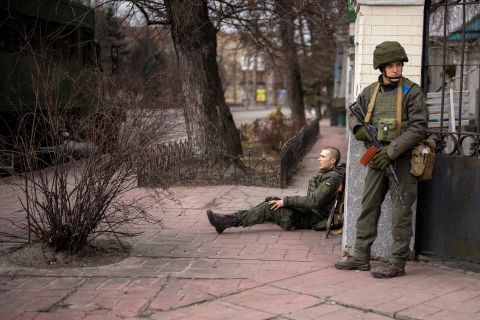 A Ukrainian soldier sits injured from crossfire inside Kyiv on February 25.