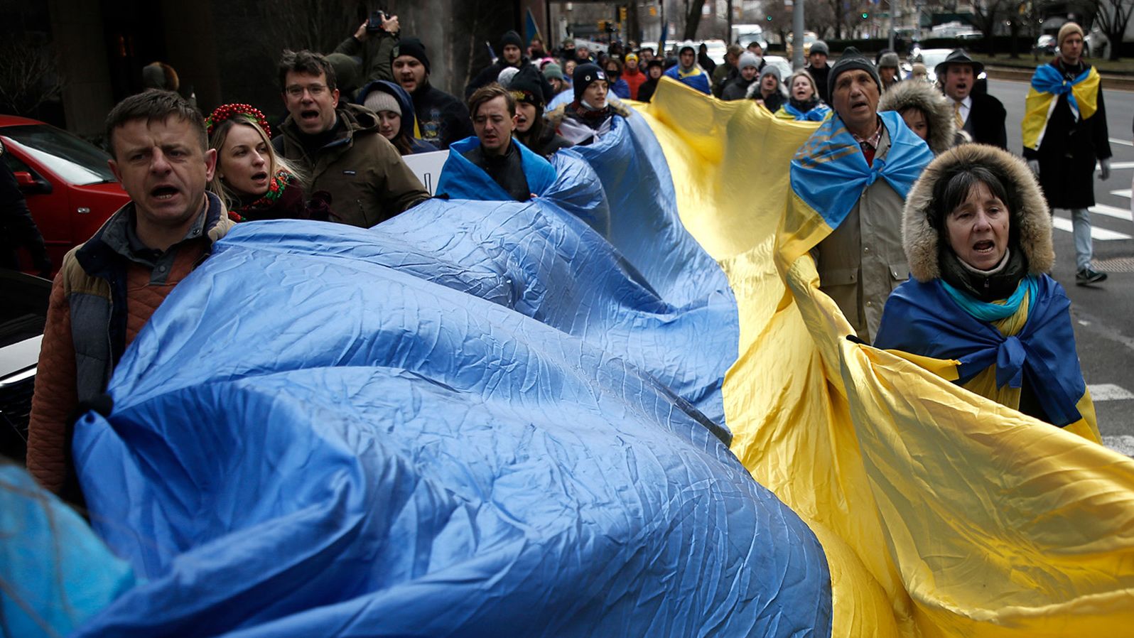Ukraine supporters march through the streets of New York with flags and signs on February 24.