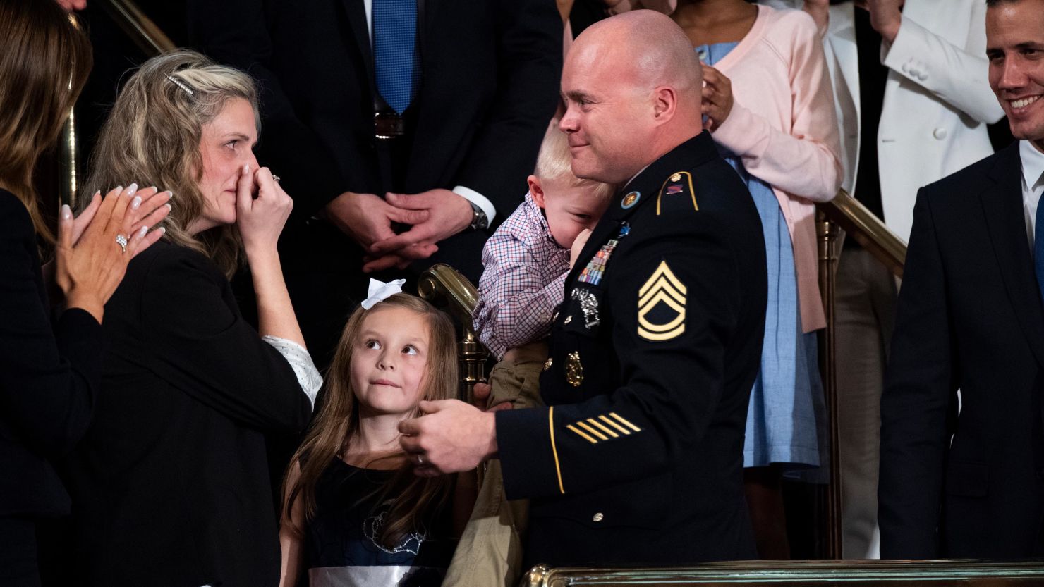 Sgt. 1st Class Townsend Williams greets his wife Amy and their children after a surprise entrance during President Donald Trump's State of the Union address in the House Chamber on Tuesday, February 4, 2020. 