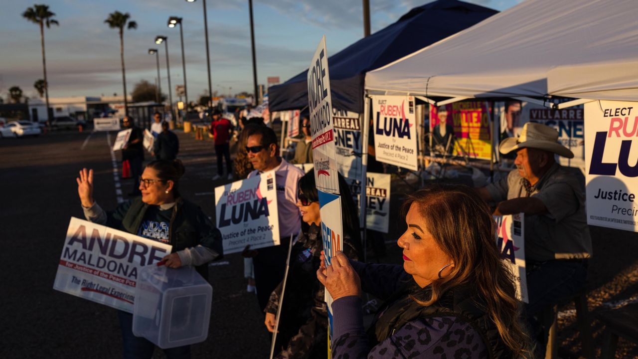 Republicans and Democrats stand side by side as they campaign for local candidates outside a polling location in Edinburg, Texas, during early voting.