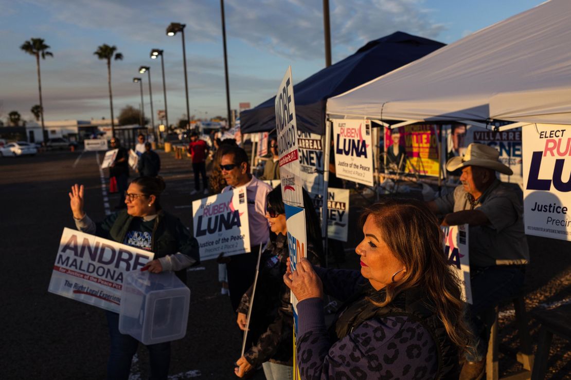 Republicans and Democrats stand side by side as they campaign for local candidates outside a polling location in Edinburg, Texas, during early voting.