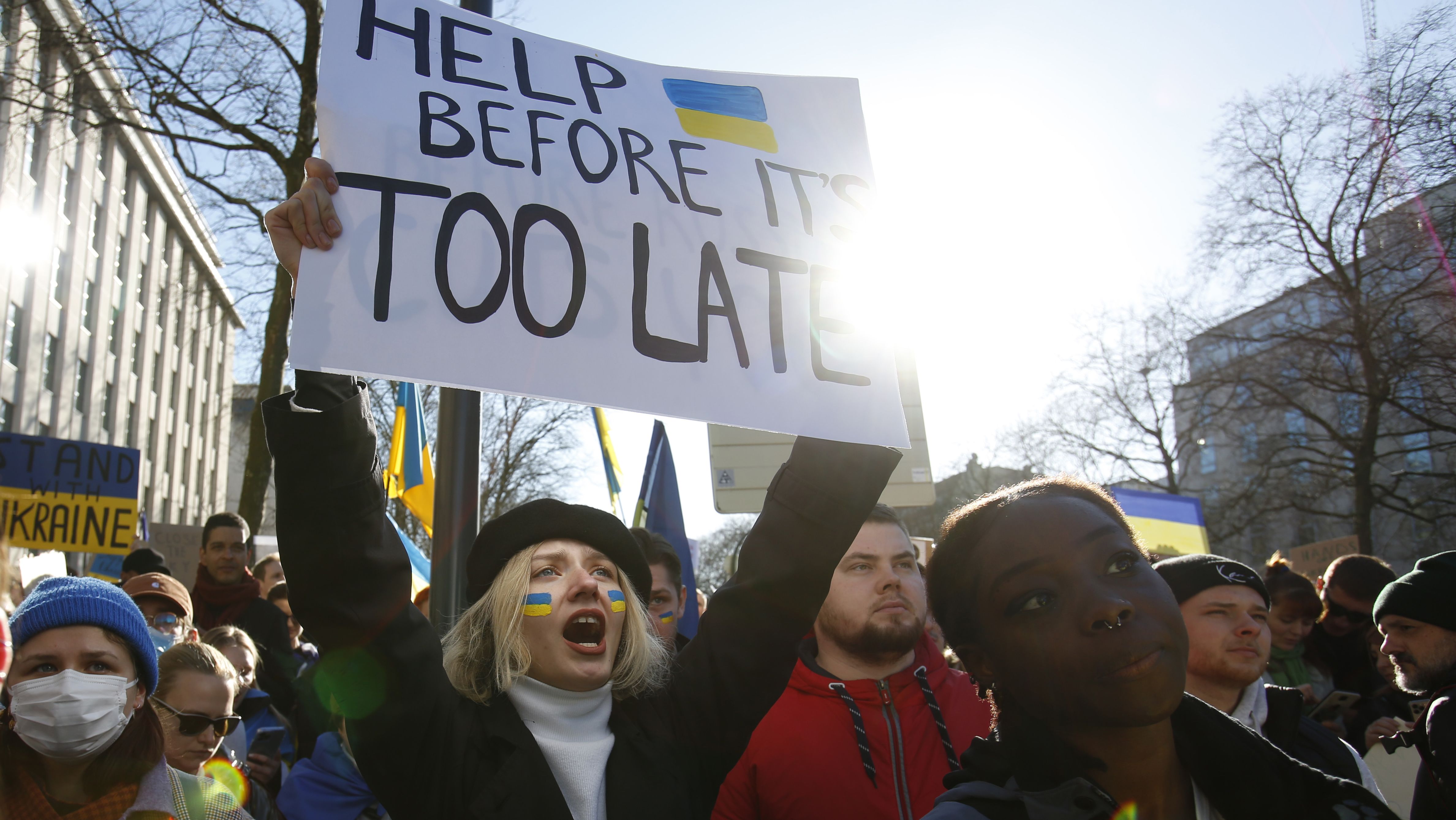 A protester holds a sign that says "help before it's too late" during a rally in Brussels, Belgium, on February 26.
