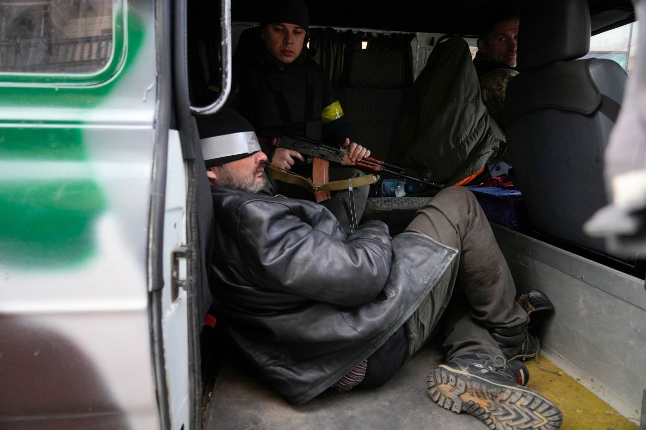 Ukrainian troops in Kyiv escort a prisoner February 