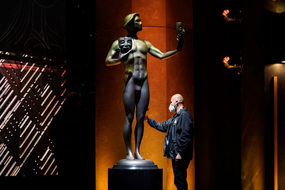 A worker cleans off a giant SAG award statue prior to the show.