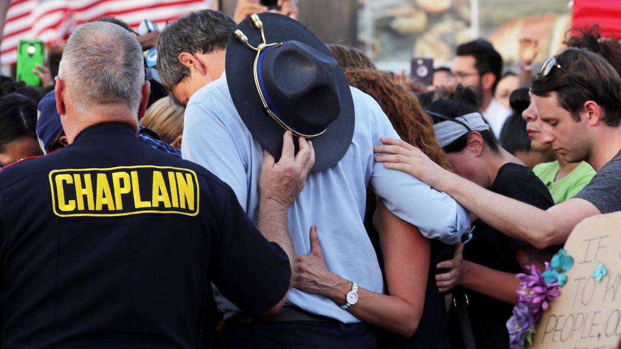 O'Rourke prays with others at a makeshift memorial outside a Walmart in El Paso, Texas, on August 7, 2019, to honor the victims of a mass shooting.