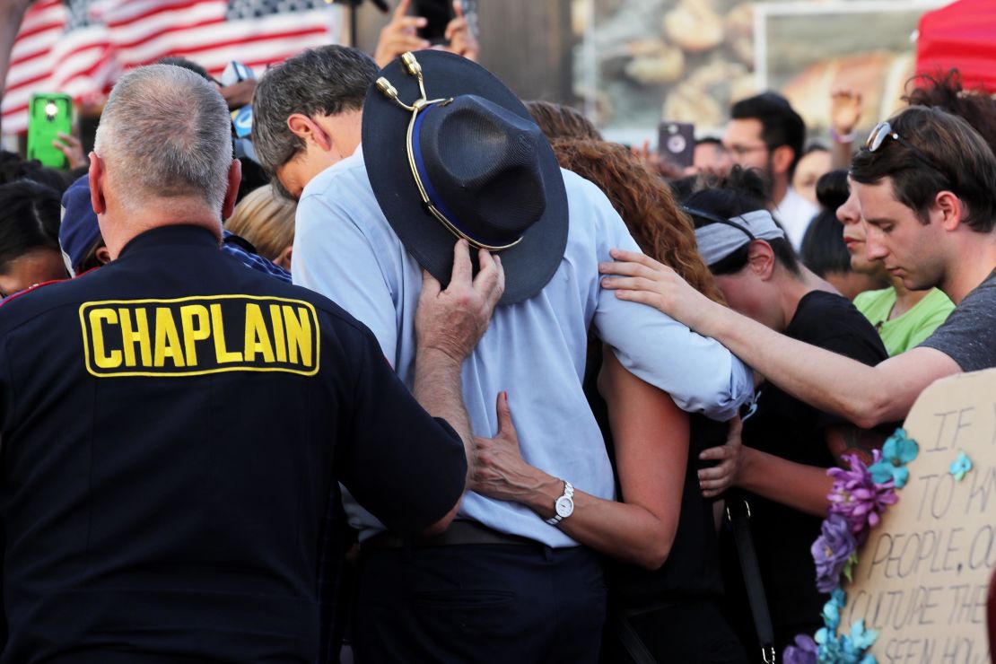 O'Rourke prays with others at a makeshift memorial outside a Walmart in El Paso, Texas, on August 7, 2019, to honor the victims of a mass shooting.