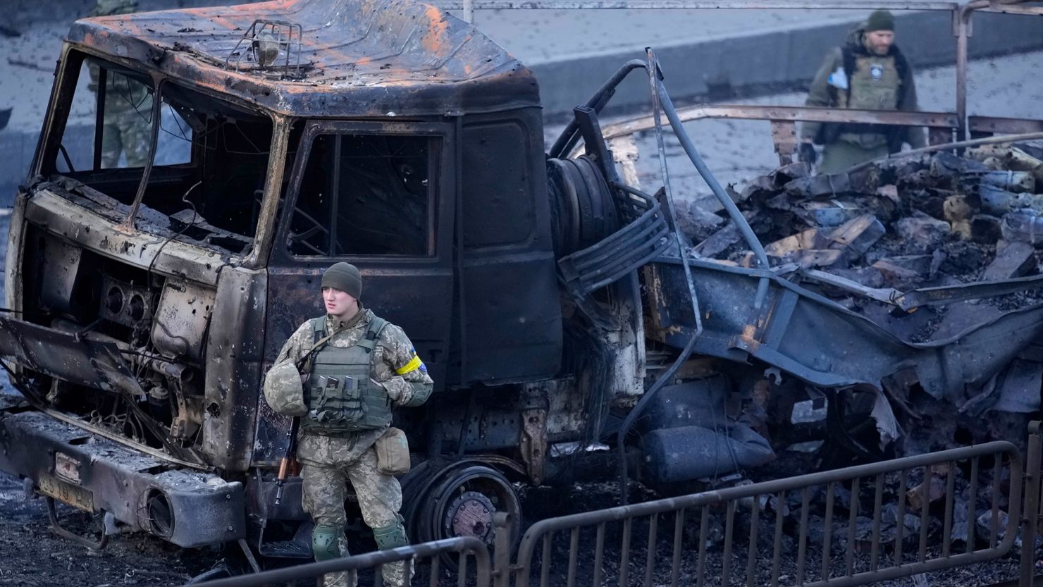 Ukrainian troops inspect the site of a Russian airstrike in Kyiv, Saturday, Feb. 26.