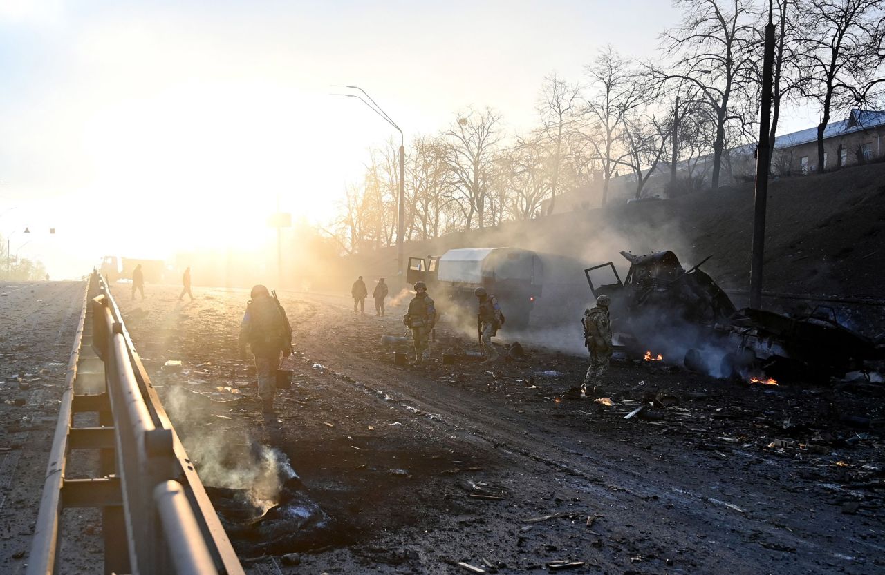 Ukrainian service members look for and collect unexploded shells after  fighting in Kyiv on February 26.