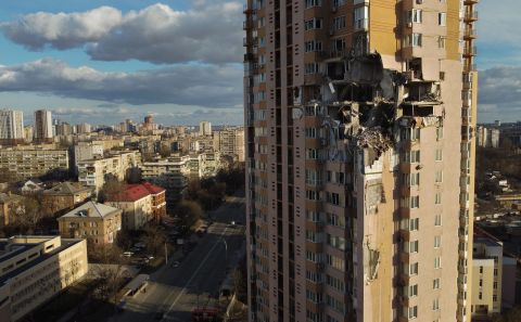 An apartment building in Kyiv is seen after it was damaged by shelling on February 26. The outer walls of several apartment units appeared to be blown out entirely, with the interiors blackened and debris hanging loose.