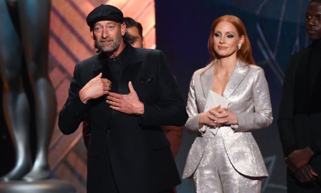 Actor Troy Kotsur uses sign language as he accepts his award for outstanding performance by a male actor in a supporting role. Kotsur, who stars in the film "CODA," is the first deaf actor to receive an individual SAG award. He and other "CODA" cast members also received the award for outstanding performance by a cast in a motion picture.