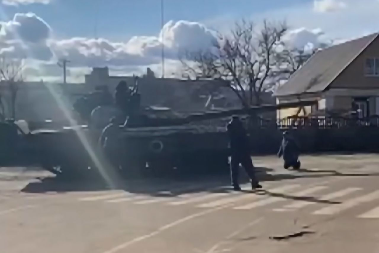 A man kneels in front of a Russian tank in Bakhmach, Ukraine, on February 26 as Ukrainian citizens attempted to stop the tank from moving forward. <a target=