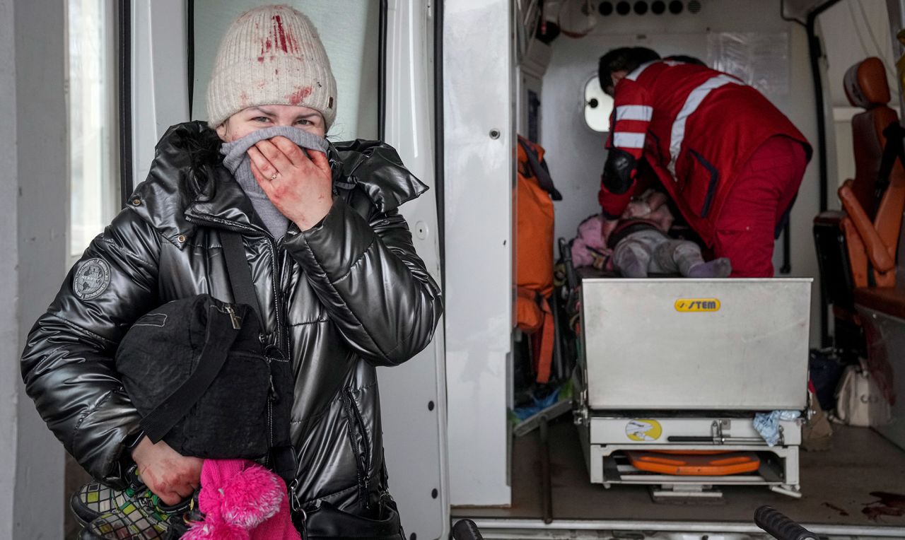 A mother stands by as a paramedic performs CPR on her daughter inside an ambulance at a hospital in Mariupol, Ukraine, on Sunday, February 27.