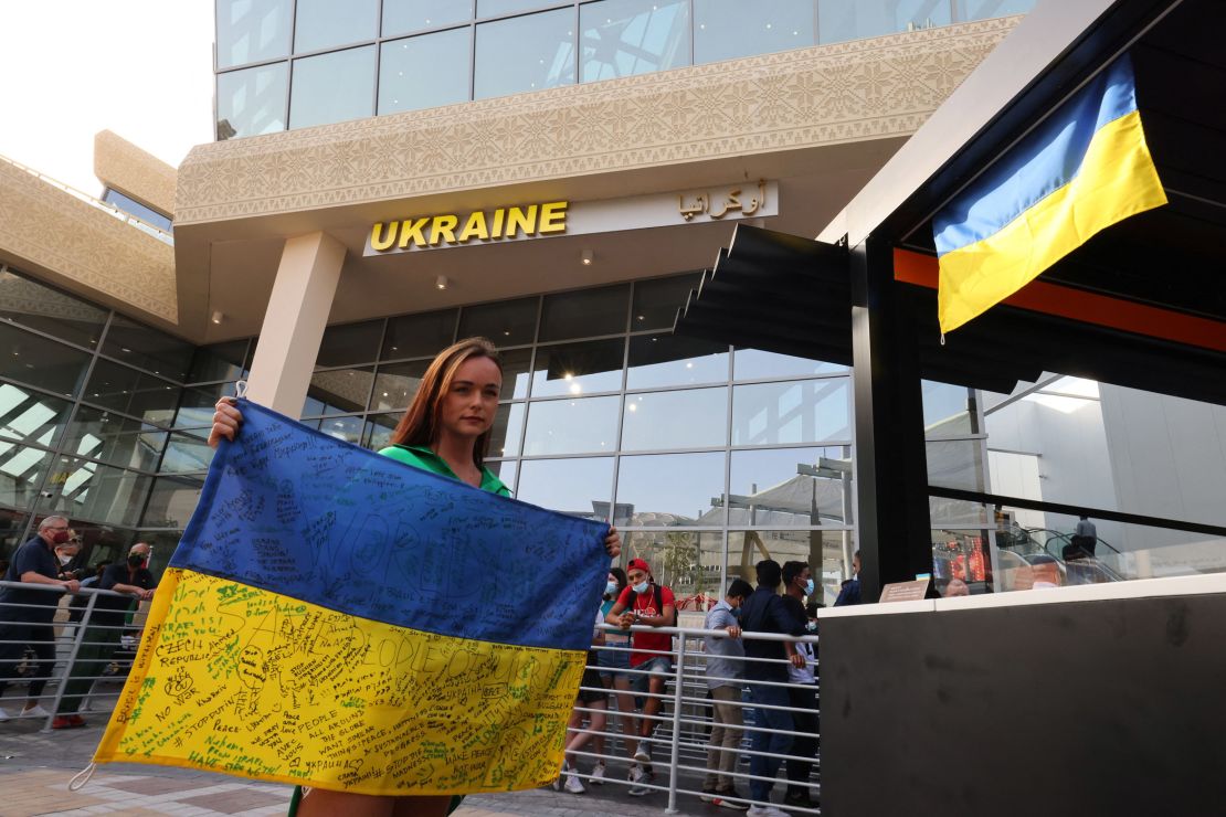 A woman poses for a picture with a signed Ukranian flag at the Ukraine pavillion at Expo 2020 in Dubai, on February 27.