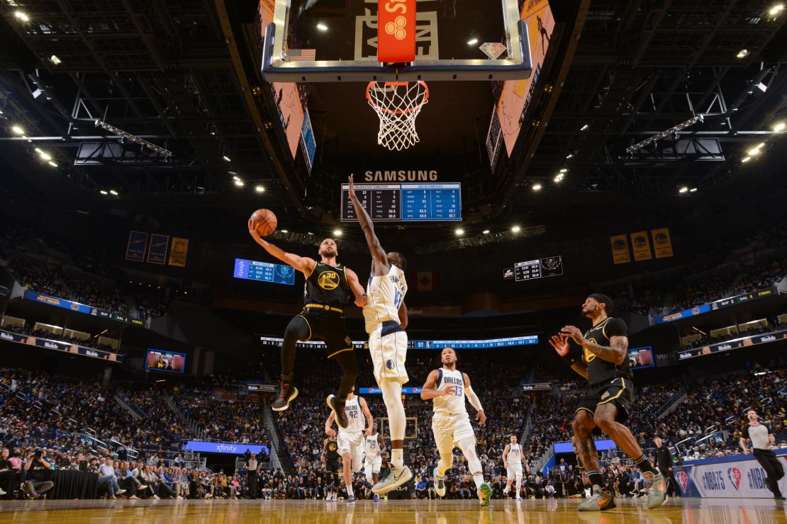 Curry drives to the basket during the game against the Mavericks.