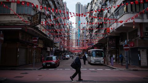 A pedestrian crosses a near empty street in Hong Kong on February 24, 2022.