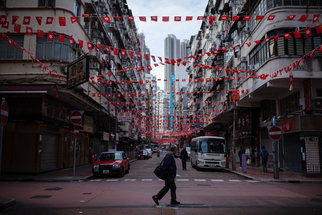 A pedestrian crosses a near empty street in Hong Kong on February 24, 2022.