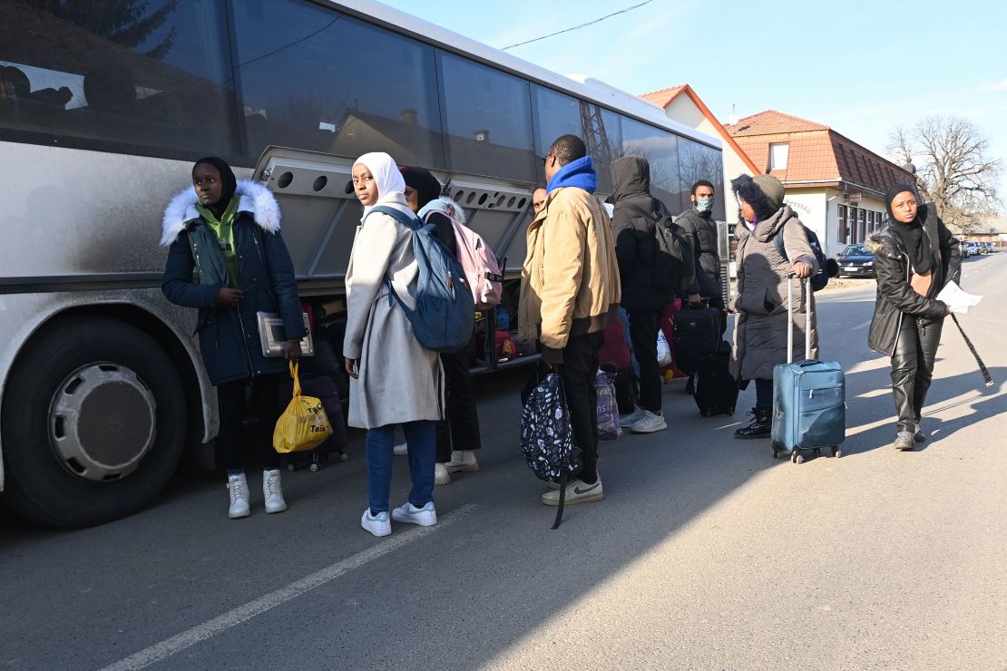 University students, including many from Nigeria, fleeing from the Ukrainian capital Kyiv, stow their luggage as they get on their transport bus near the Hungarian-Ukrainian border in the village of Tarpa in Hungary on February 28, 2022. 