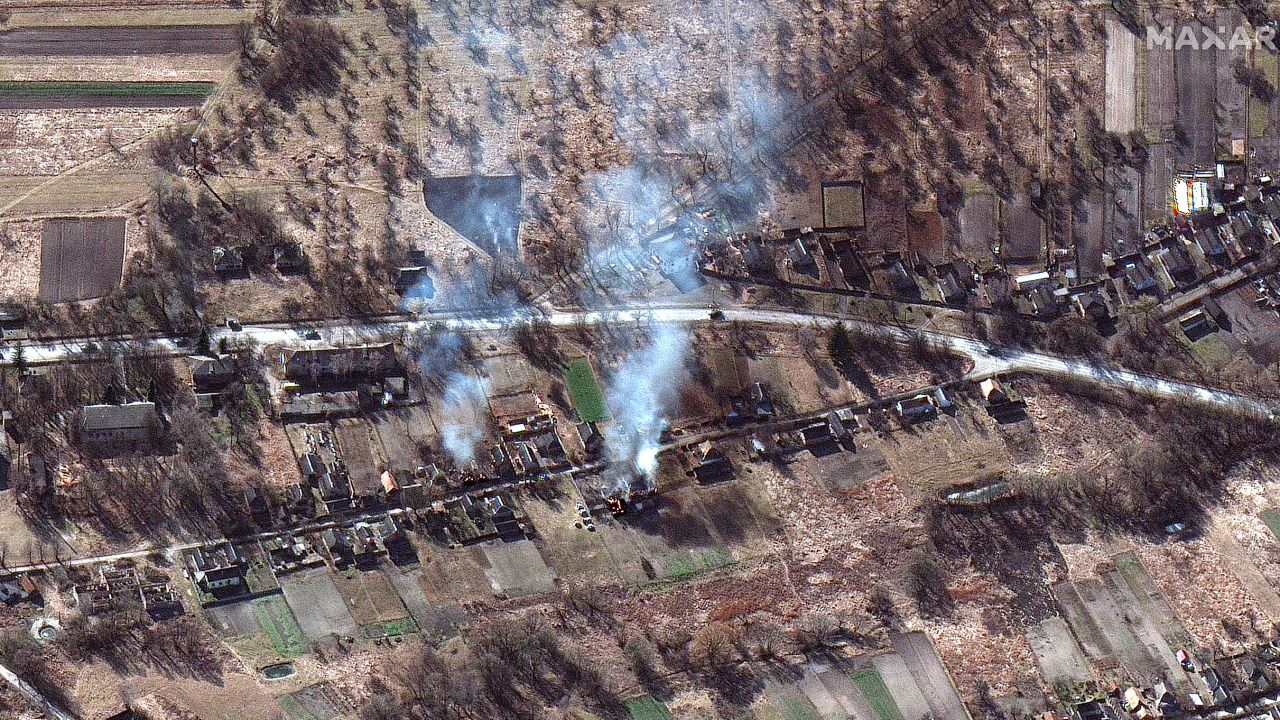 The Russian convoy is seen along with smoke rising from what appears to be burning homes, northwest of Invankiv, Ukraine.