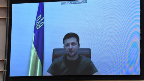 Ukrainian President Volodymyr Zelensky appears on a screen as he speaks in a video conference. 