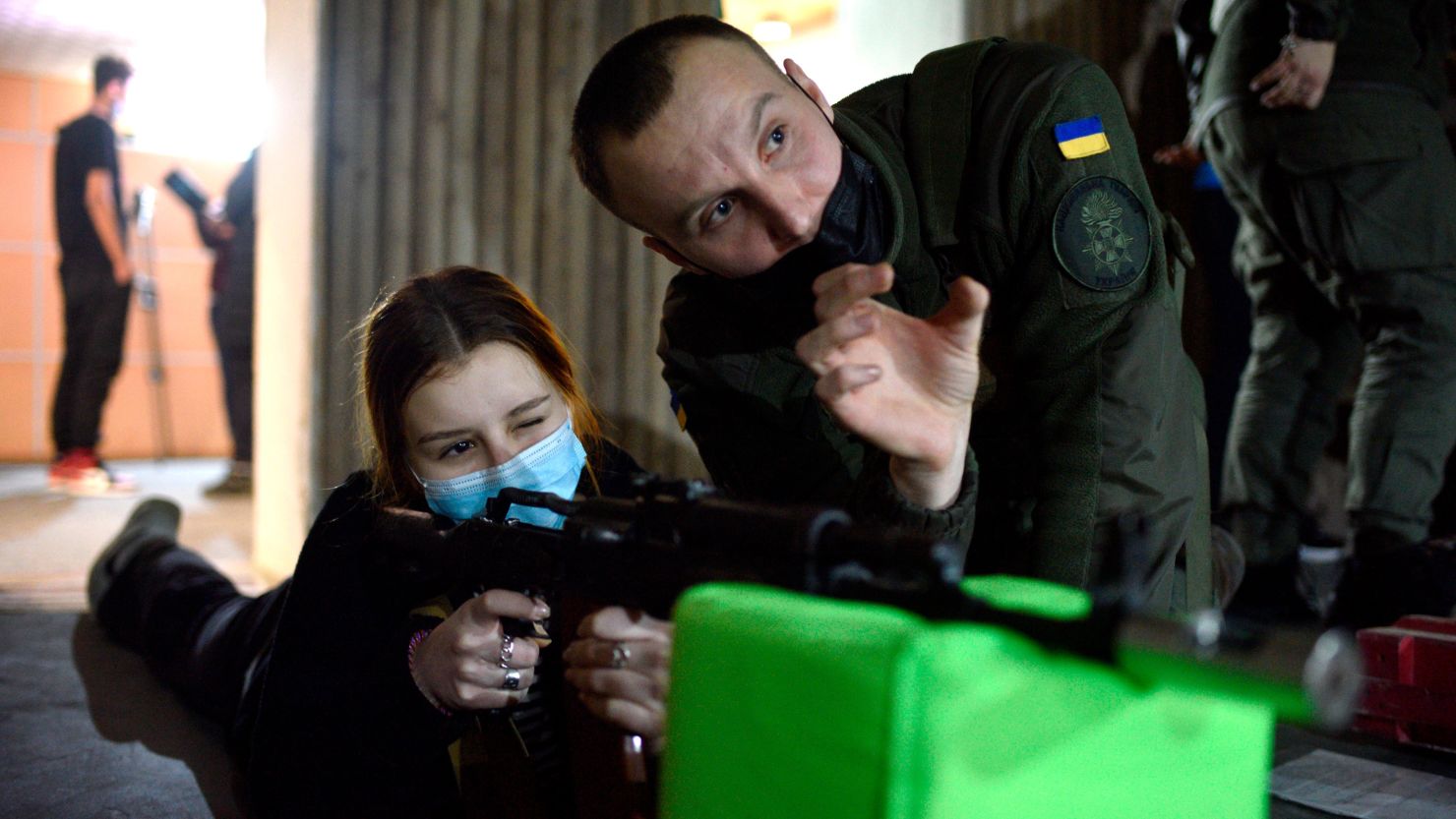 A young volunteer aims at a target during the shooting exercises for high school students.