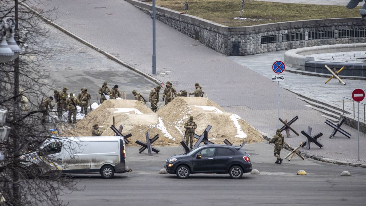 Soldiers are seen around piles of sand used to blocking a road in the Ukrainian capital, Kyiv.