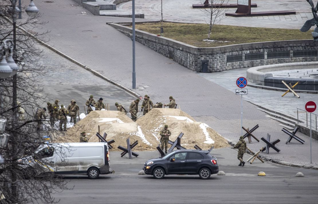 Soldiers are seen around piles of sand used to blocking a road in the Ukrainian capital, Kyiv.