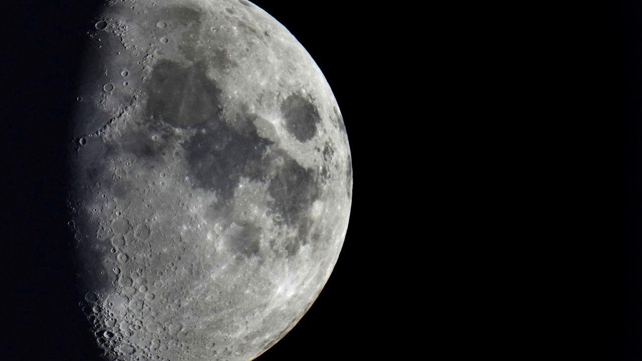 Impact craters can be seen across the surface of the moon.