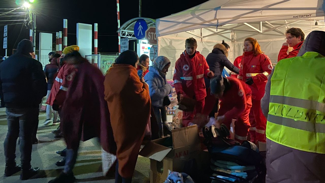 Romanian Red Cross workers hand out blankets to refugees from Ukraine who crossed the border at Sighetu Marmatiei, Romania, shortly before midnight on February 28.