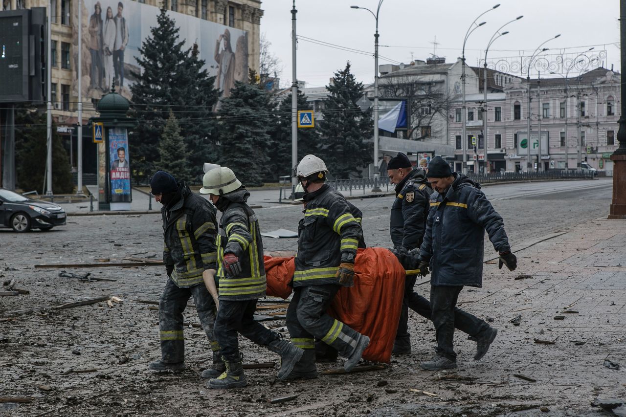 Ukrainian emergency workers carry a body of a victim following shelling that hit the City Hall building in Kharkiv on March 1.