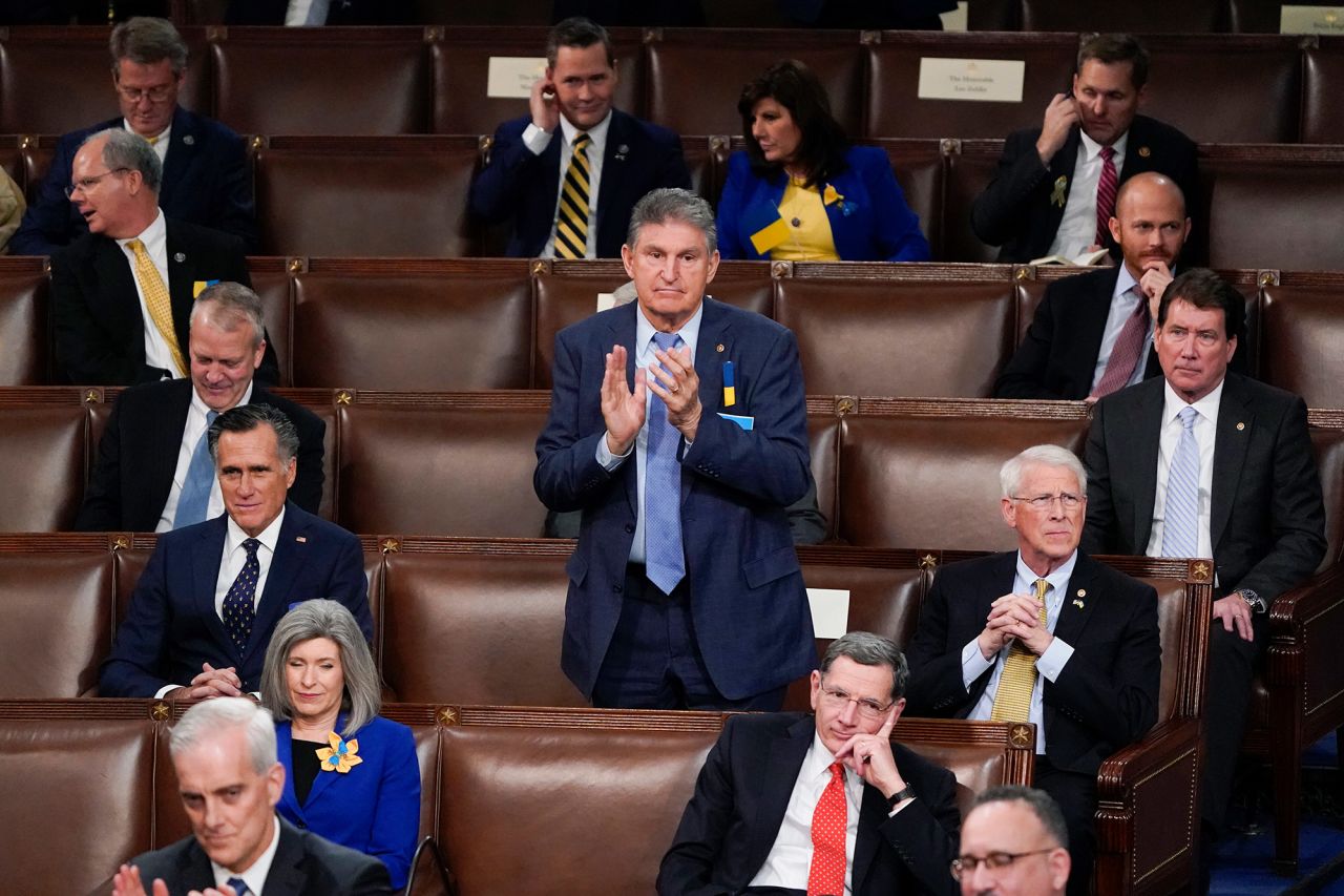 Sen. Joe Manchin, a Democrat from West Virginia, stands and applauds as he sits among Republican senators in the House chamber.